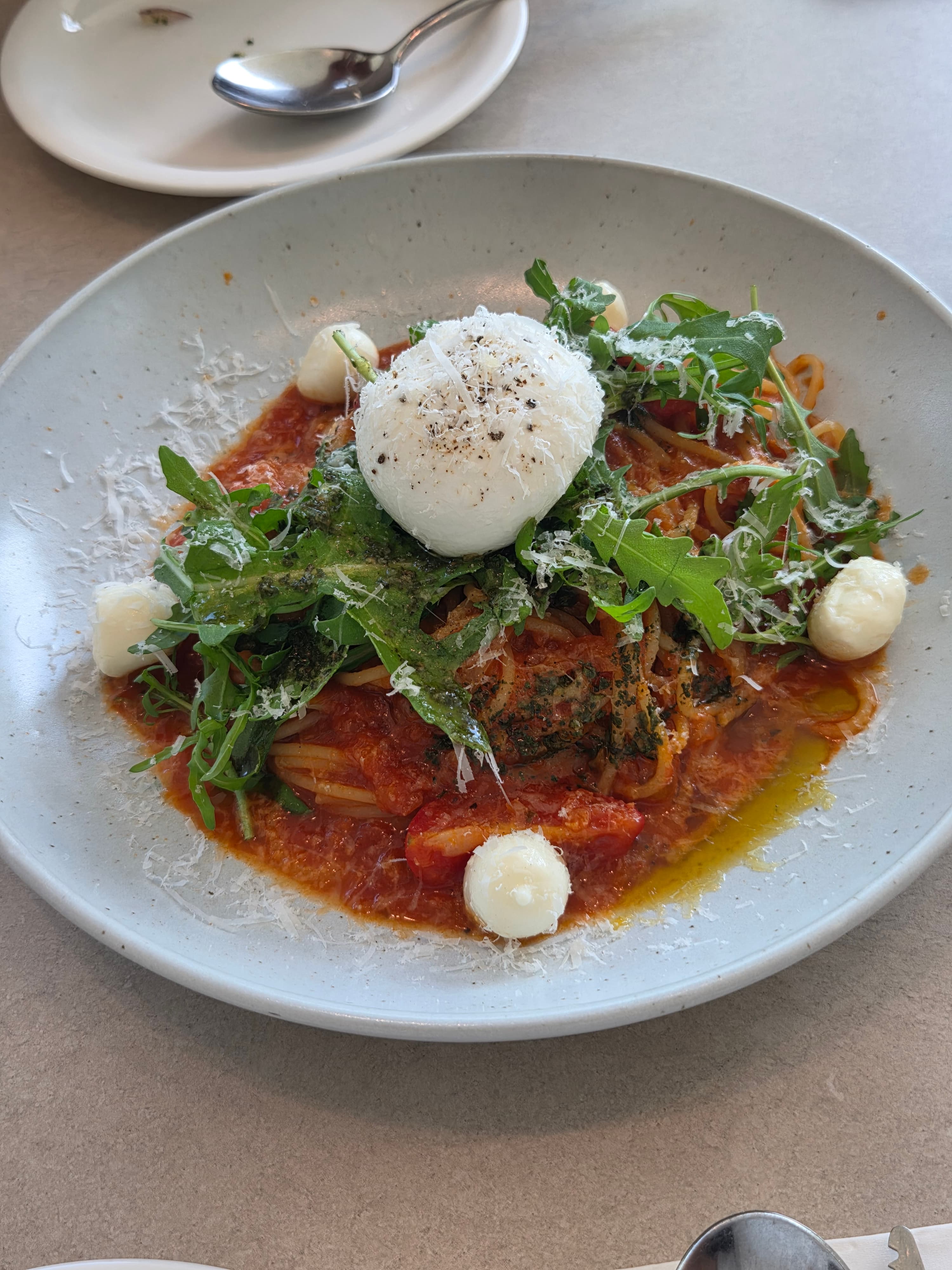 Burrata cheese tomato pasta at Seasoner Jeonju with a whole burrata ball, bocconcini mozzarella, arugula, shaved parmesan and basil pesto