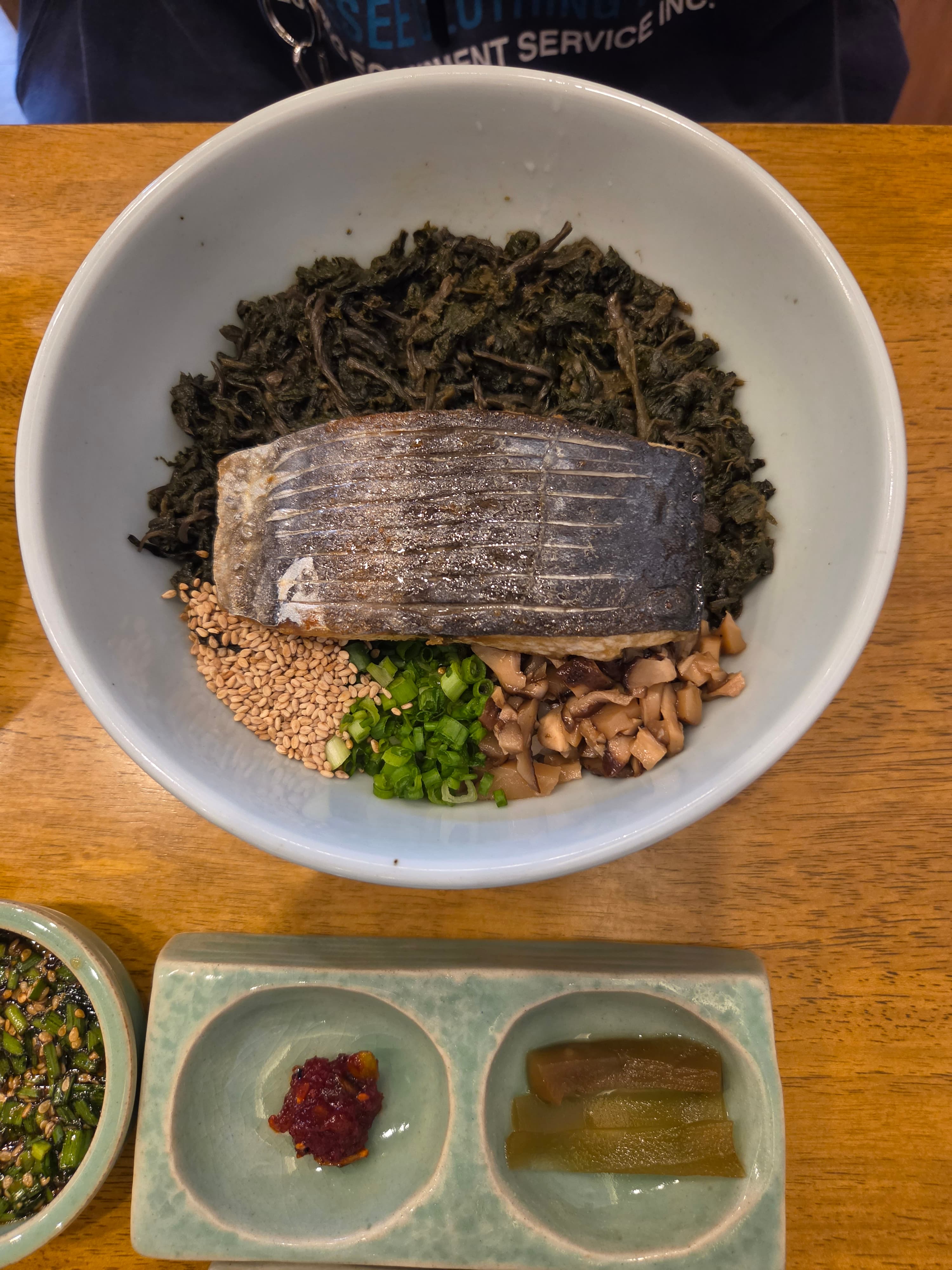 香宅的鲅鱼香菇饭 — 一整块烤鲅鱼放在香菇菜拌饭上,配谷物、小葱和蘑菇